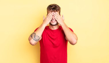 Genç yakışıklı adam gülümsüyor ve mutlu hissediyor, iki eliyle gözlerini kapatıyor ve inanılmaz bir sürpriz bekliyor.