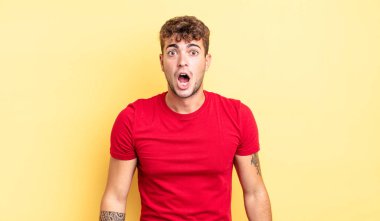 Genç ve yakışıklı bir adam şok olmuş ya da şaşırmış görünüyor, ağzı açık bir şekilde 