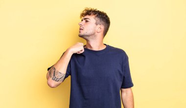 Genç ve yakışıklı bir adam stresli, endişeli, yorgun ve hayal kırıklığına uğramış, gömleğini çekiştirmiş, sorunlu görünüyor.