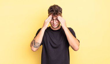 Genç ve yakışıklı bir adam stresli ve hayal kırıklığına uğramış görünüyor. Baskı altında çalışıyor ve sorunları var.