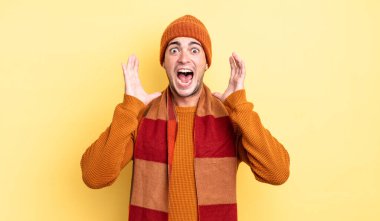 Genç ve yakışıklı bir adam beklenmedik bir sürpriz yüzünden şaşkın ve heyecanlı, güler yüzlü, şaşkın ve mutlu hissediyor.