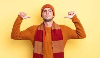 Genç yakışıklı adam gururlu, kibirli ve kendinden emin, tatmin olmuş ve başarılı görünüyor, kendini işaret ediyor.