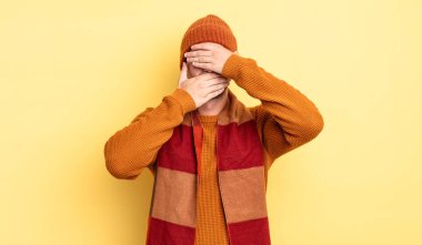 Genç yakışıklı adam kameraya hayır diyen iki eliyle yüzünü kapatıyor! Resimler reddediliyor ya da yasaklanıyor