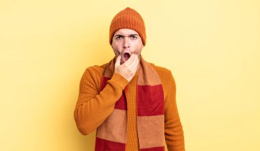 Ağzı ve gözleri açık, eli çenesinde genç ve yakışıklı bir adam. Hoş olmayan bir şok geçiriyor.