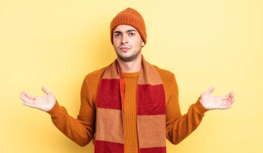 Genç yakışıklı adam şaşkın ve şaşkın hissediyor, doğru cevap veya karardan emin değil, bir seçim yapmaya çalışıyor.