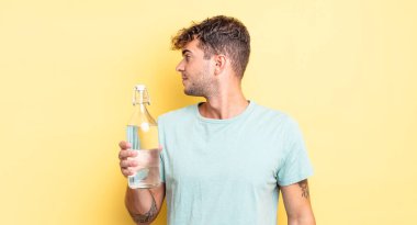 Profilde genç yakışıklı bir adam hayal kuruyor, hayal kuruyor ya da hayal kuruyor. su kavramı