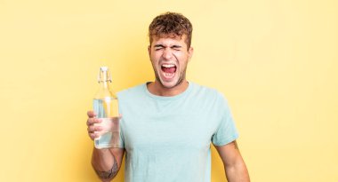 Genç yakışıklı adam agresif bir şekilde bağırıyor, çok kızgın görünüyor. su kavramı