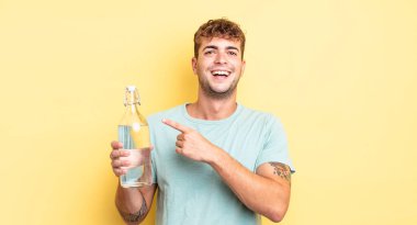 Genç yakışıklı adam heyecanlı ve şaşırmış görünüyor. su kavramı