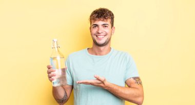 Genç yakışıklı adam neşeyle gülümsüyor, mutlu hissediyor ve bir konsept gösteriyor. su kavramı