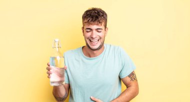 Genç yakışıklı bir adam komik bir şakaya yüksek sesle gülüyor. su kavramı