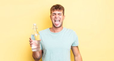 Genç, yakışıklı, neşeli ve asi tavırlı, şaka yapan ve dilini dışarı çıkaran bir adam. su kavramı