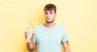 Genç ve yakışıklı bir adam üzgün, üzgün ya da kızgın hissediyor ve yan tarafa bakıyor. su kavramı