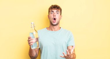 Genç ve yakışıklı bir adam şok olmuş ve şaşırmış hissediyor. su kavramı