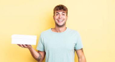 Genç yakışıklı adam mutlu ve hoş bir şekilde şaşırmış görünüyor. beyaz kutu kavramı