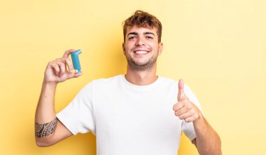 Genç ve yakışıklı bir adam gururlu, olumlu gülümsüyor. astım konsepti