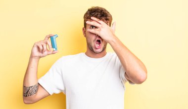 Genç, yakışıklı adam şok olmuş, korkmuş ya da korkmuş görünüyor. astım konsepti