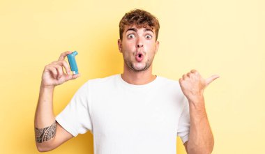 İnanamadığı için şaşırmış genç ve yakışıklı bir adam. astım konsepti