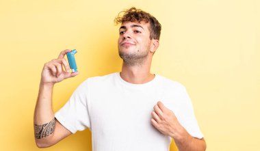 Genç yakışıklı adam kibirli, başarılı, pozitif ve gururlu görünüyor. astım konsepti