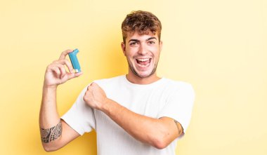 Genç yakışıklı adam kendini mutlu hissediyor ve bir meydan okumayla yüzleşiyor ya da kutluyor. astım konsepti