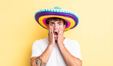 Genç ve yakışıklı bir adam şok olmuş ve korkmuş hissediyor. Meksika şapkası konsepti