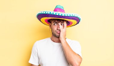 Genç yakışıklı bir adam bıkkın, hayal kırıklığına uğramış ve yorucu bir geceden sonra uykulu hissediyor. Meksika şapkası konsepti