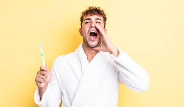 Genç yakışıklı adam mutlu hissediyor, elleri ağzının kenarında bağırıyor. diş fırçası kavramı