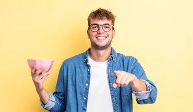 Genç ve yakışıklı bir adam kamerayı işaret ederek seni seçiyor. boş kase kavramı