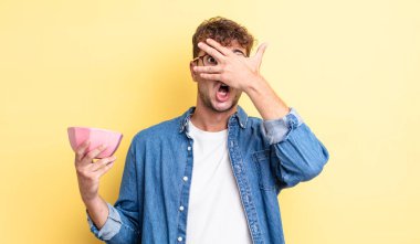 Genç, yakışıklı adam şok olmuş, korkmuş ya da korkmuş görünüyor. boş kase kavramı