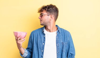 Profilde genç yakışıklı bir adam hayal kuruyor, hayal kuruyor ya da hayal kuruyor. boş kase kavramı