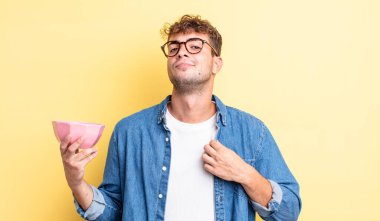 Genç yakışıklı adam kibirli, başarılı, pozitif ve gururlu görünüyor. boş kase kavramı