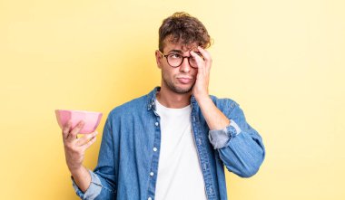 Genç yakışıklı bir adam bıkkın, hayal kırıklığına uğramış ve yorucu bir geceden sonra uykulu hissediyor. boş kase kavramı