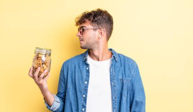 Profilde genç yakışıklı bir adam hayal kuruyor, hayal kuruyor ya da hayal kuruyor. kurabiye şişesi konsepti