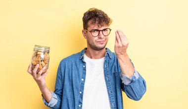 Genç yakışıklı adam kapiş ya da para hareketi yapıyor, sana ödemeni söylüyor. kurabiye şişesi konsepti