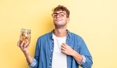 Genç yakışıklı adam kibirli, başarılı, pozitif ve gururlu görünüyor. kurabiye şişesi konsepti