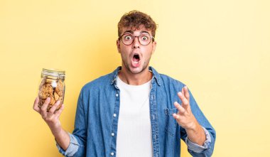 Genç yakışıklı adam, inanılmaz bir sürprizle şaşkına dönmüş ve hayrete düşmüştü. kurabiye şişesi konsepti