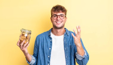 Genç yakışıklı adam kendini mutlu hissediyor, bir çözüm ya da fikir bulduğuna şaşırıyor. kurabiye şişesi konsepti