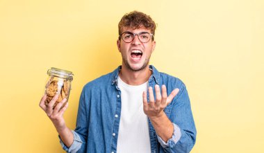 Genç yakışıklı adam umutsuz, sinirli ve stresli görünüyor. kurabiye şişesi konsepti