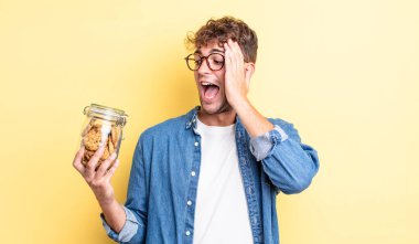 Genç yakışıklı adam mutlu, heyecanlı ve şaşırmış hissediyor. kurabiye şişesi konsepti