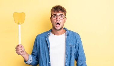 Genç ve yakışıklı bir adam çok şaşırmış ya da şaşkın görünüyor. Sineklik konsepti