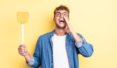 Genç yakışıklı adam mutlu hissediyor, elleri ağzının kenarında bağırıyor. Sineklik konsepti