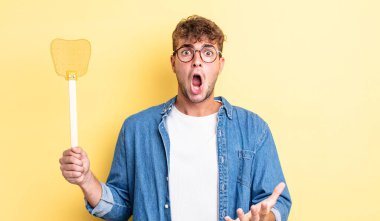 Genç ve yakışıklı bir adam şok olmuş ve şaşırmış hissediyor. Sineklik konsepti