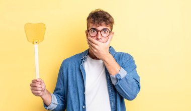 Genç ve yakışıklı bir adam elleri ile ağzını kapatıyor ve şok geçiriyor. Sineklik konsepti