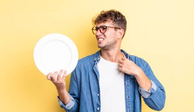 Genç ve yakışıklı adam stresli, endişeli, yorgun ve hayal kırıklığına uğramış hissediyor. boş tabak kavramı