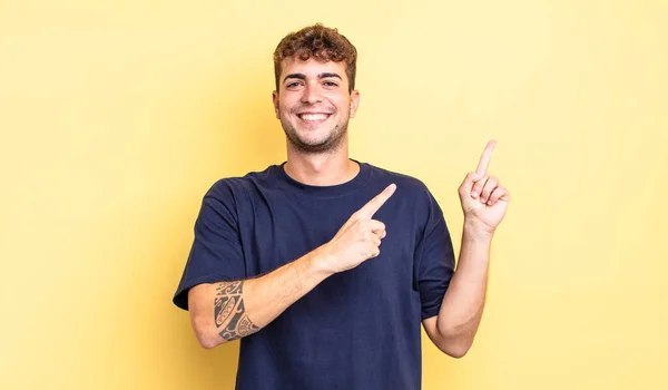 Mladý Pohledný Muž Šťastně Usmívá Ukazuje Stranu Nahoru Oběma Rukama — Stock fotografie