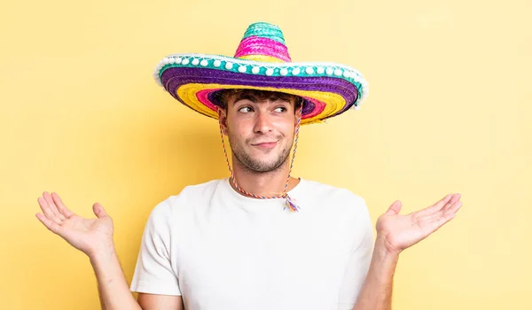 Jovem Homem Bonito Sentindo Intrigado Confuso Duvidoso Conceito Chapéu Mexicano — Fotografia de Stock