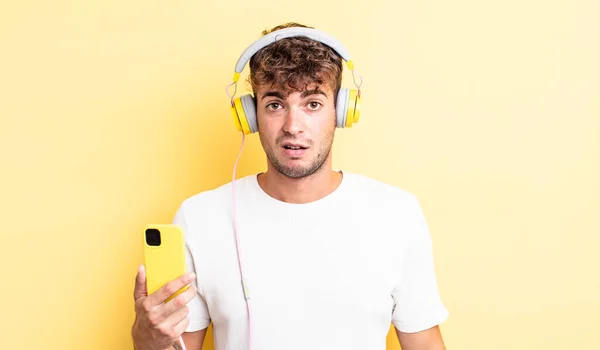 Jeune Homme Beau Sentant Perplexe Confus Casque Concept Smartphone — Photo