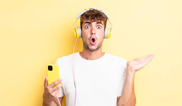 Joven Hombre Guapo Mirando Sorprendido Sorprendido Con Mandíbula Caída Sosteniendo —  Fotos de Stock