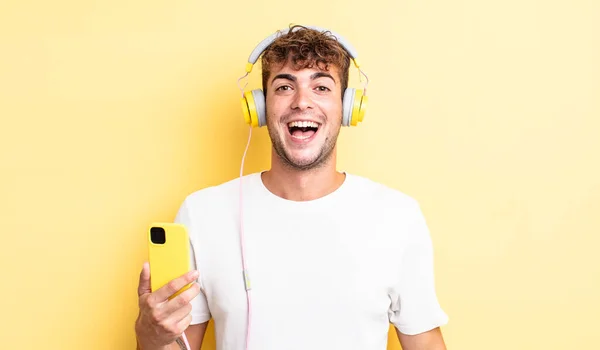 Jonge Knappe Man Die Gelukkig Aangenaam Verrast Uitziet Koptelefoon Smartphone — Stockfoto