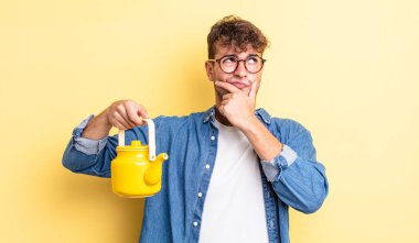 Genç yakışıklı adam düşünüyor, kuşkulu ve şaşkın hissediyor. Çaydanlık konsepti.