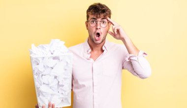 Genç yakışıklı adam şaşırmış görünüyor, yeni bir düşünce, fikir ya da konsept fark ediyor. kağıt toplar çöp konsepti